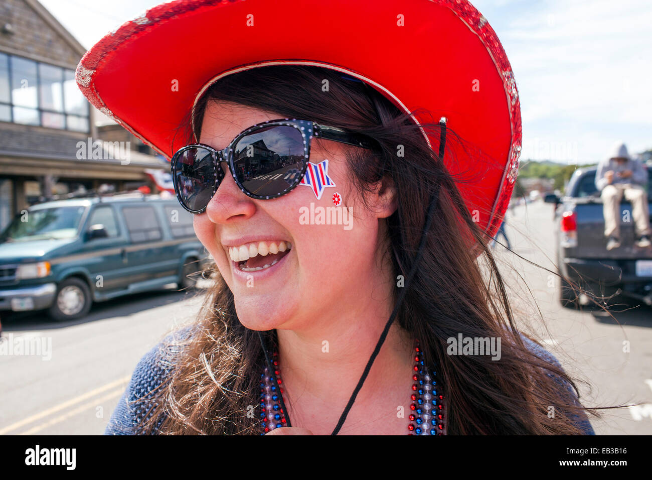 Caucasian woman wearing cowboy hat and face paint in street Stock Photo
