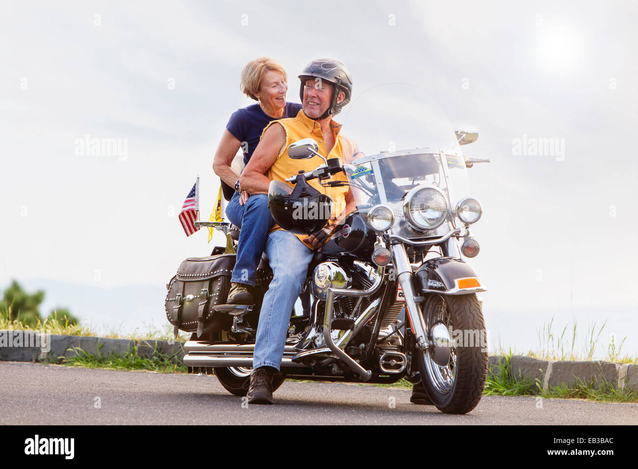 Older Caucasian couple smiling on motorcycle Stock Photo