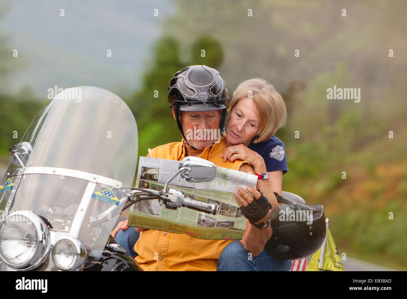 Older Caucasian couple reading map on motorcycle Stock Photo