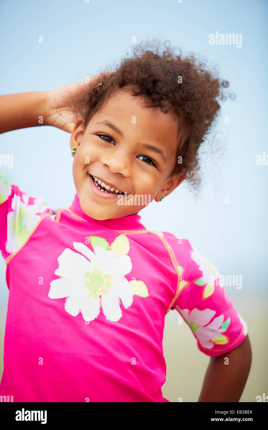 Mixed race girl smiling on beach Stock Photo