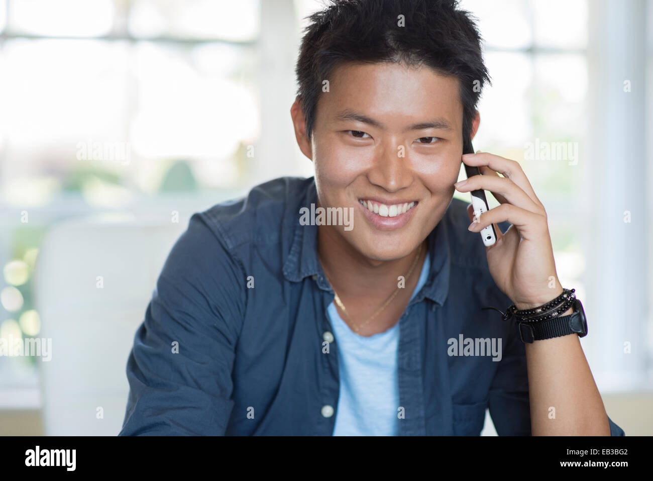 Korean man talking on cell phone indoors Stock Photo Alamy