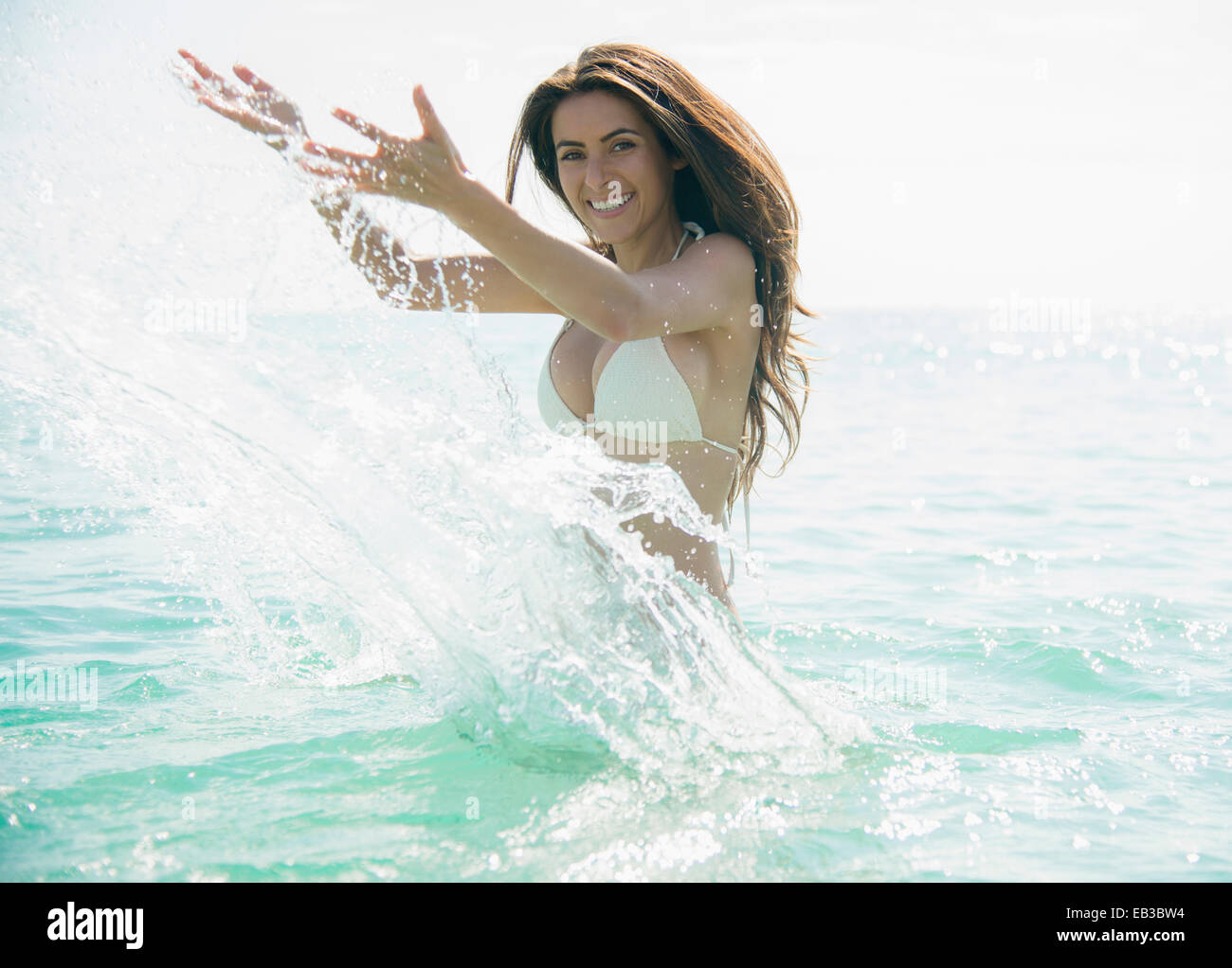 Caucasian woman splashing in ocean Stock Photo