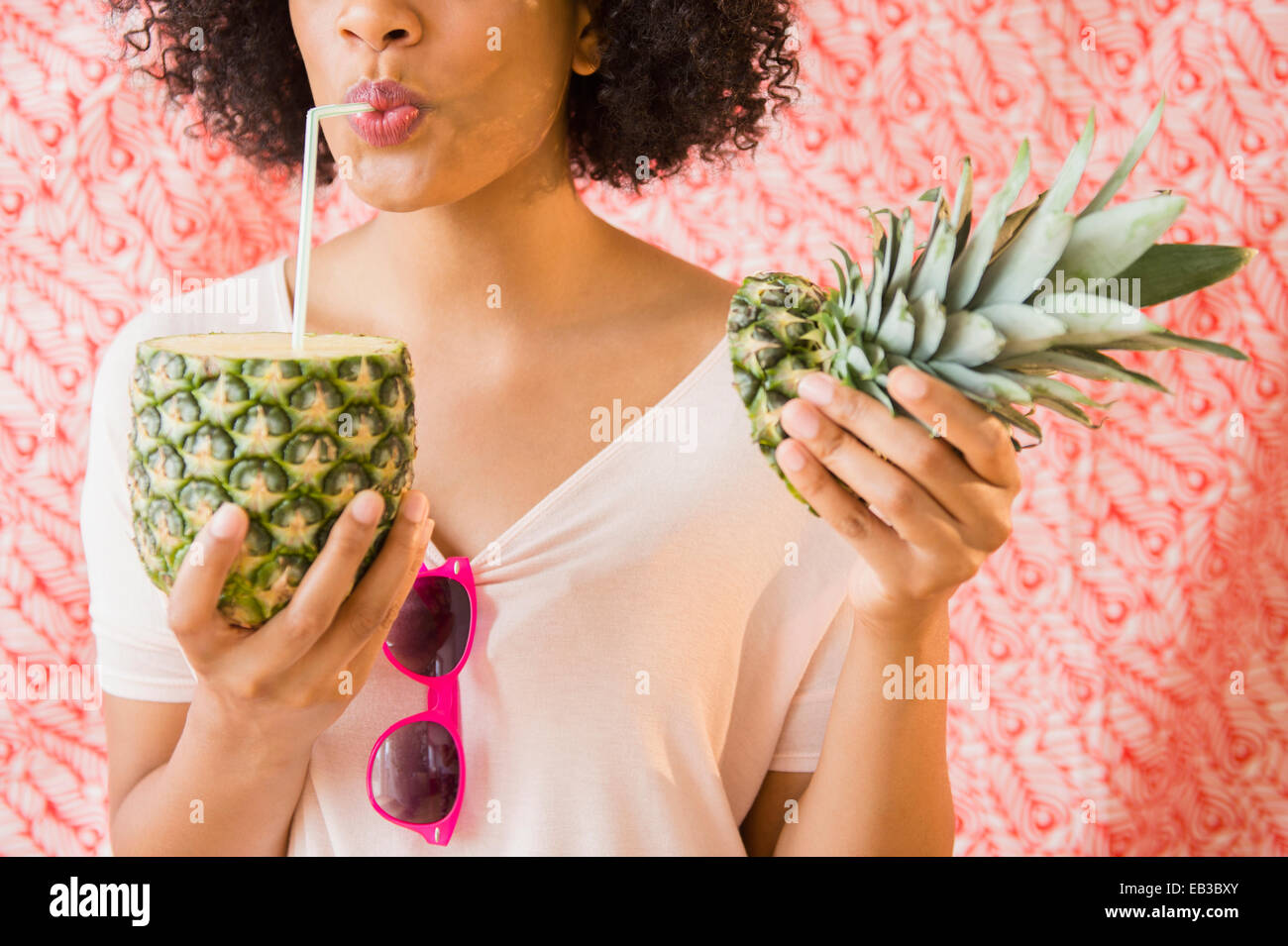 Woman drinking juice from fresh pineapple Stock Photo
