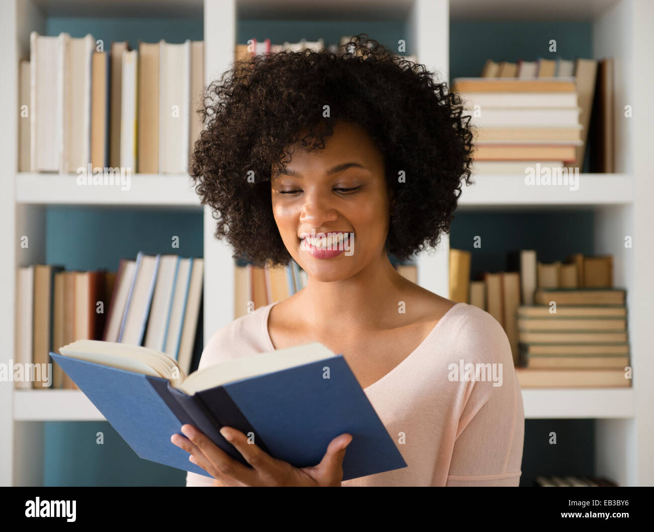 Woman reading book in library Stock Photo