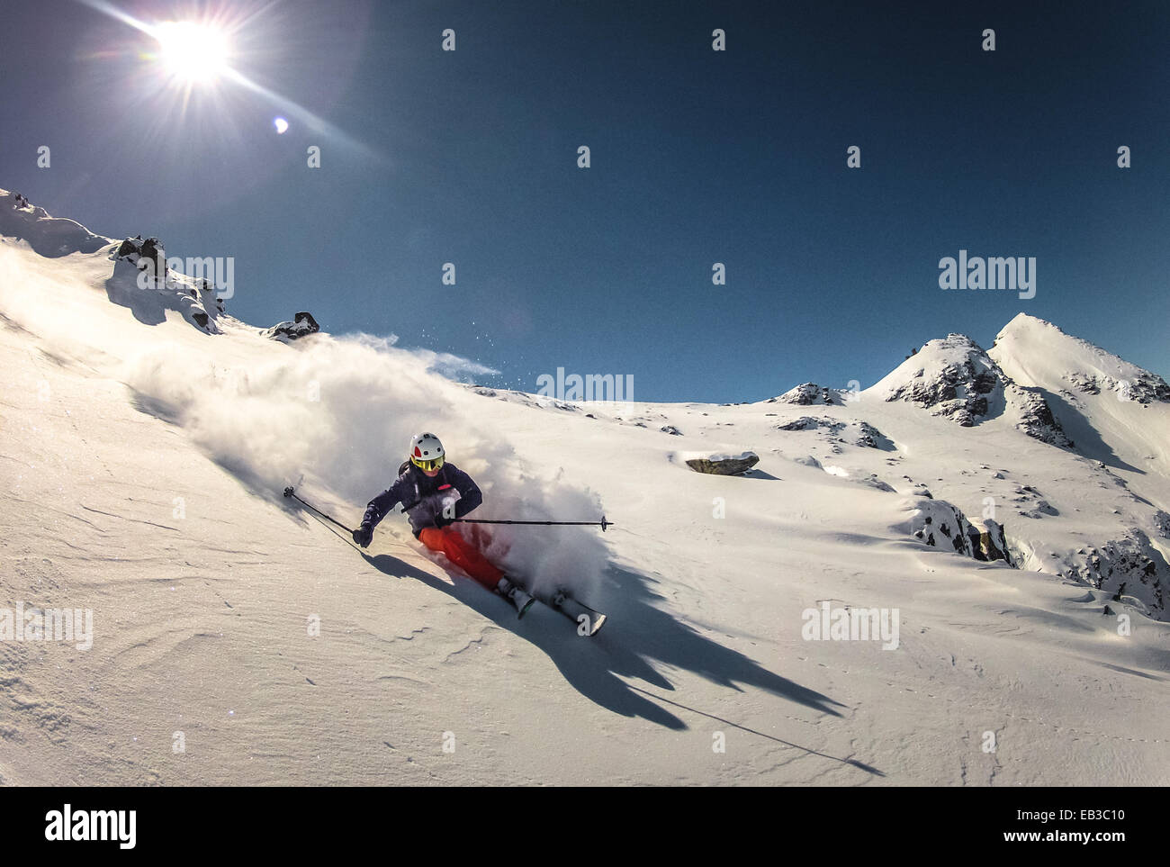 Austria, Skier doing turn in fresh powder snow Stock Photo