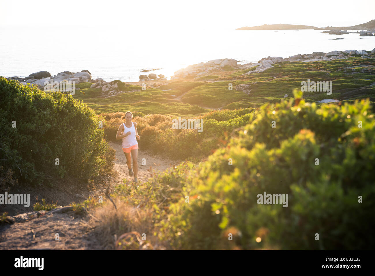 Woman trail running by the coast, Corsica, France Stock Photo