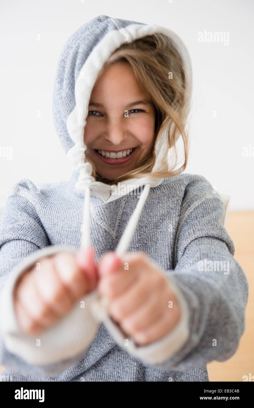 Caucasian girl pulling strings of hood Stock Photo