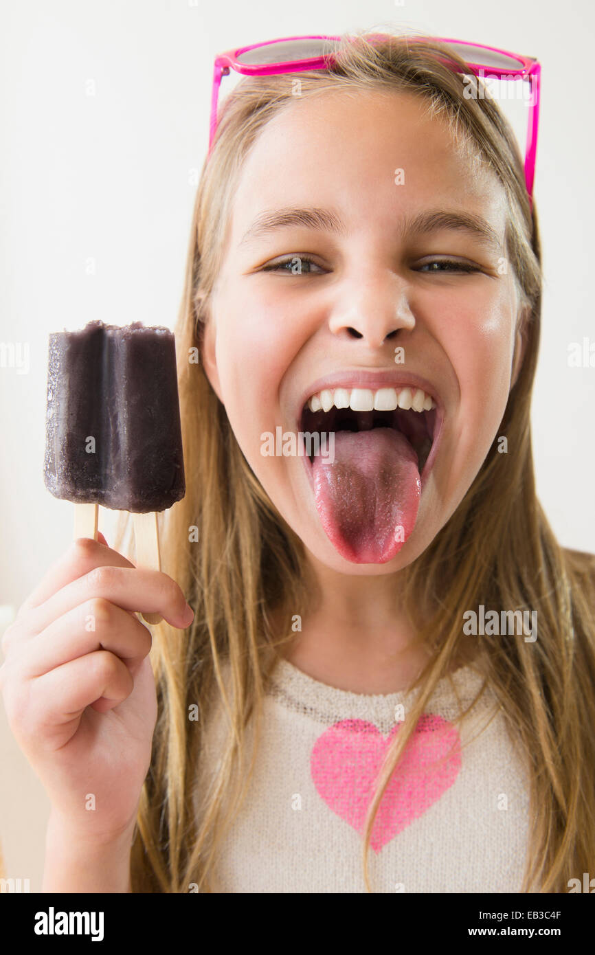 Caucasian girl with stained tongue from grape popsicle Stock Photo