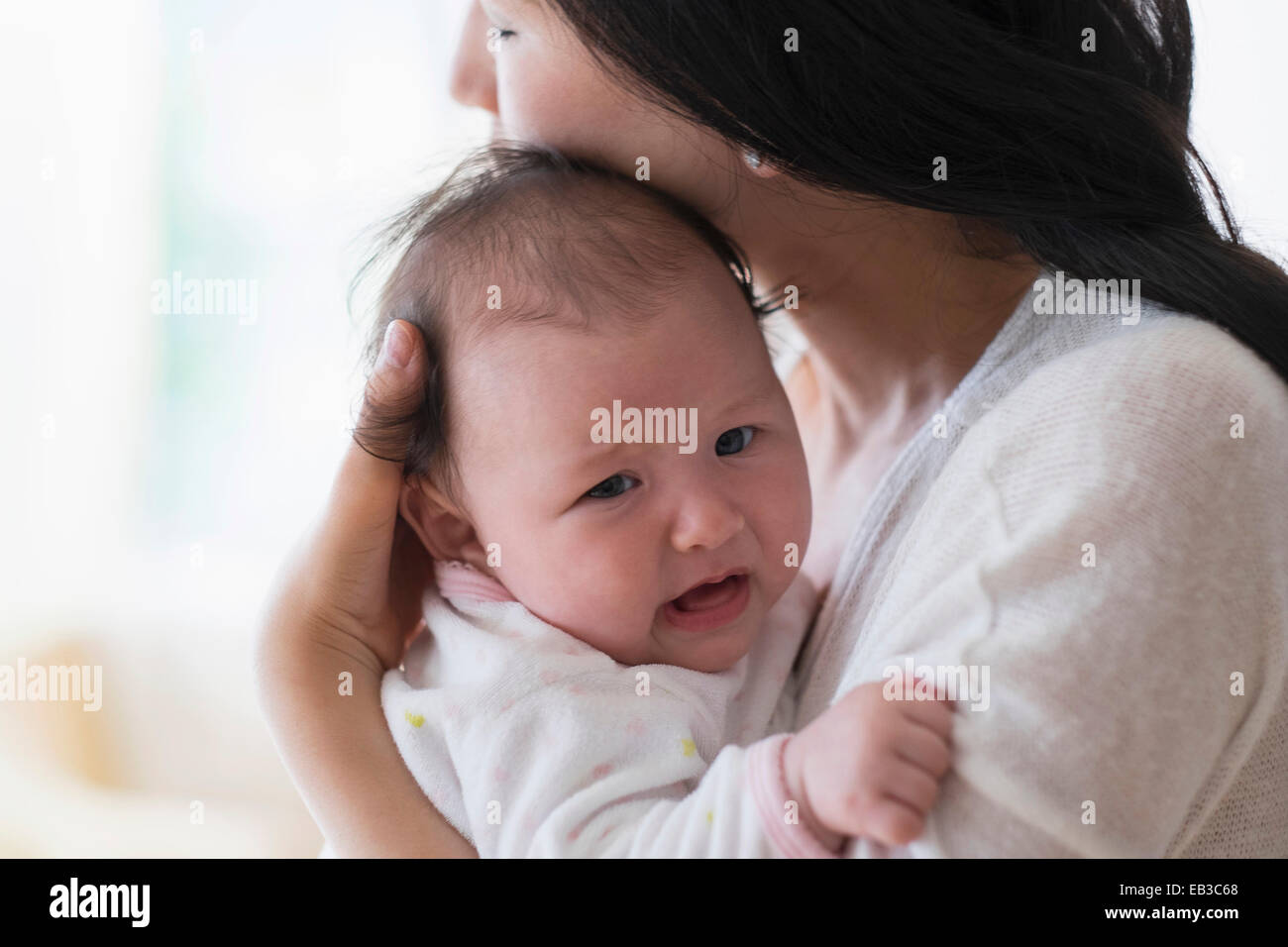 Asian mother comforting crying baby Stock Photo