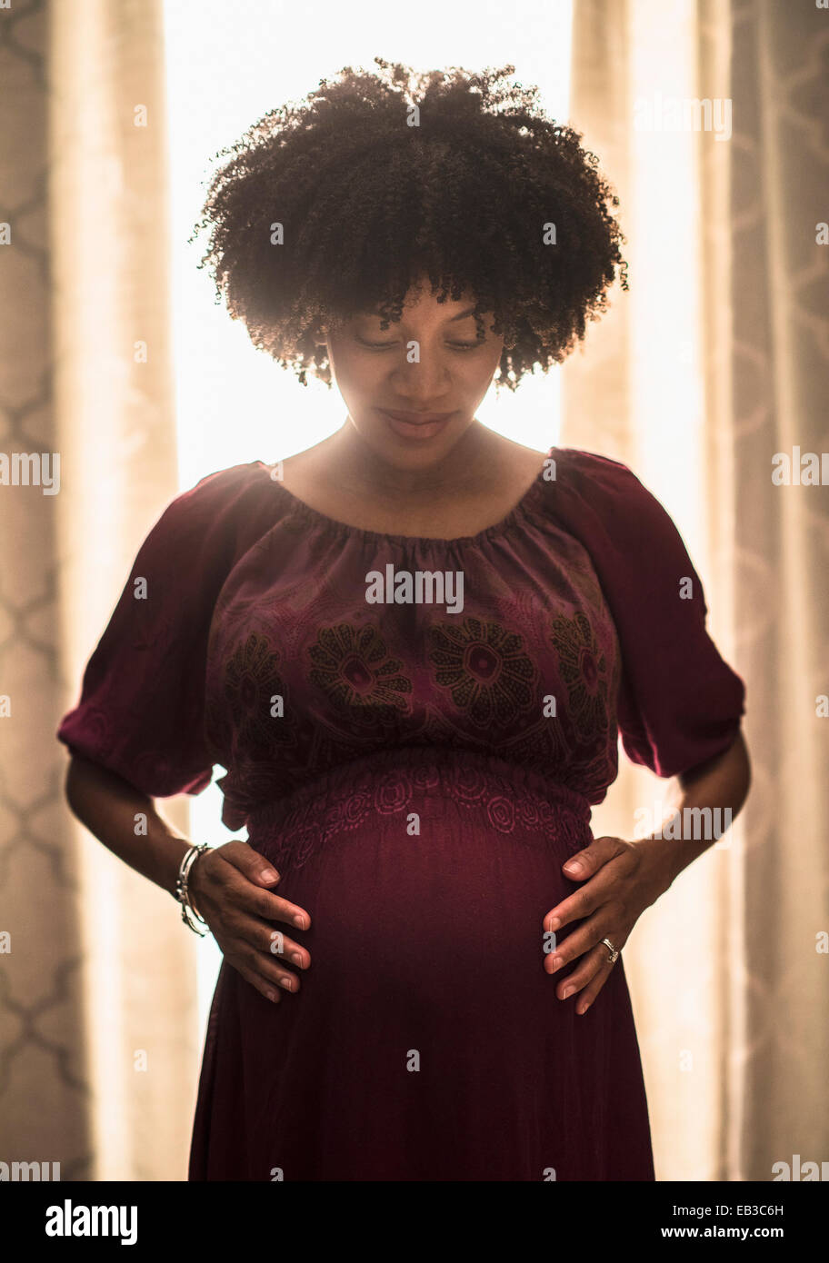 Pregnant African American mother holding her stomach Stock Photo - Alamy