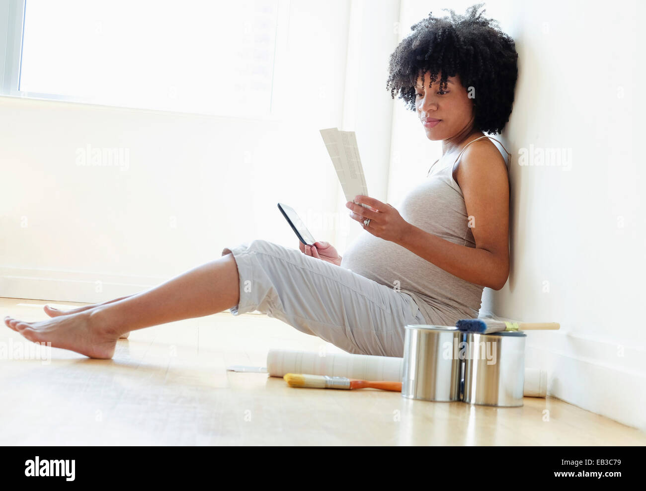 Pregnant African American mother examining paint swatches for nursery