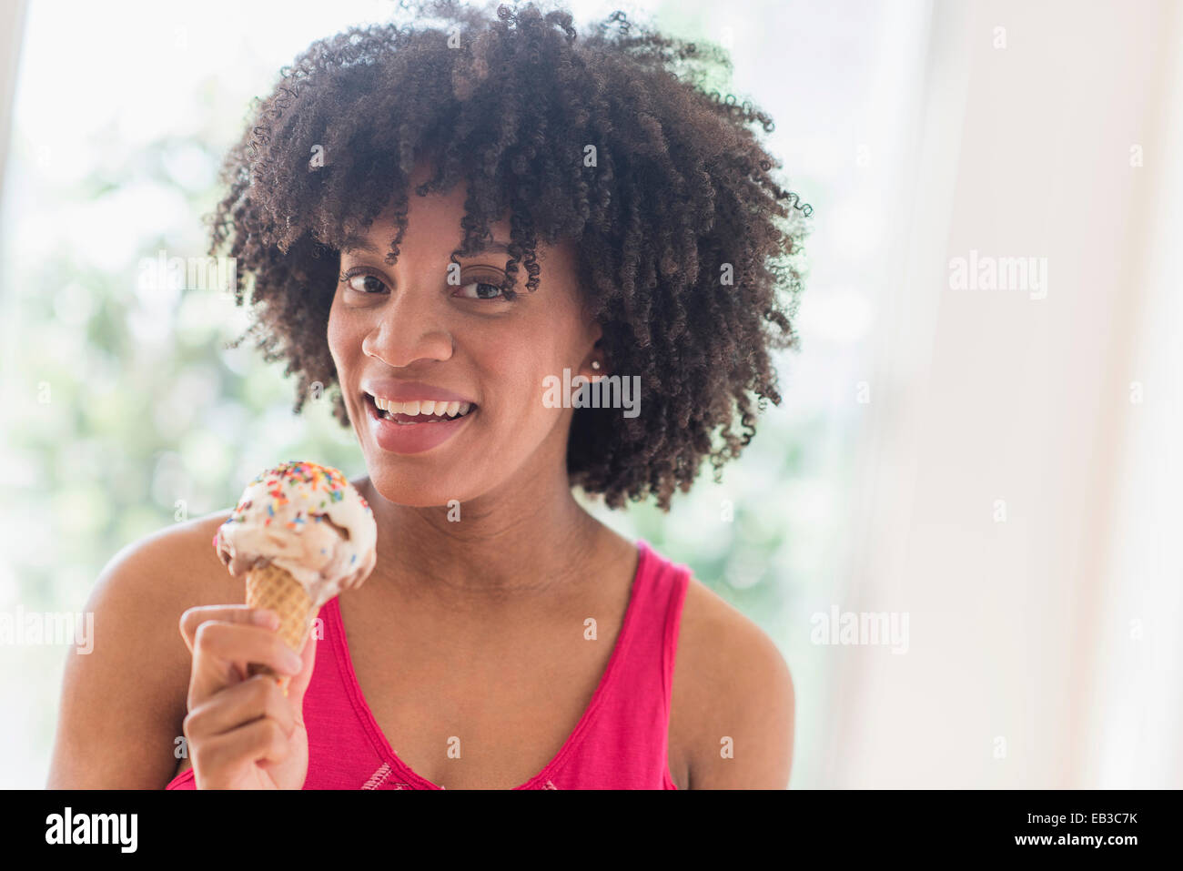 African American woman eating ice cream cone Stock Photo