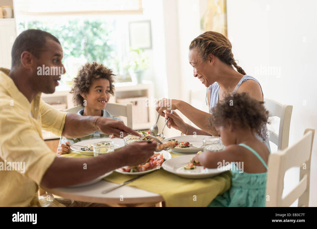 Family eating together at dining room table Stock Photo