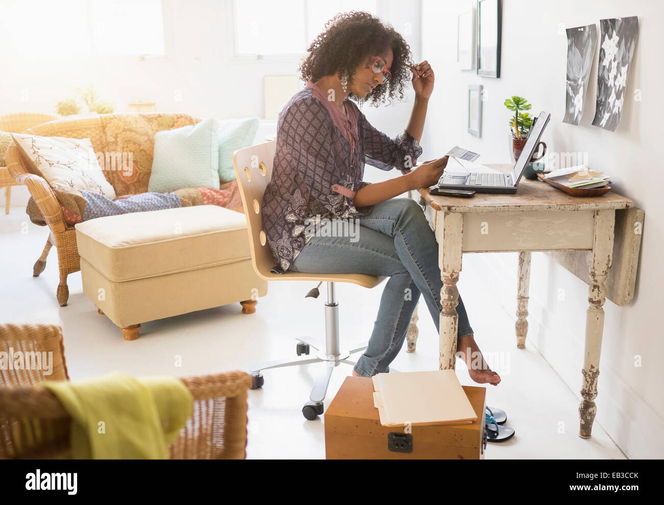 Mixed race woman using laptop in living room Stock Photo