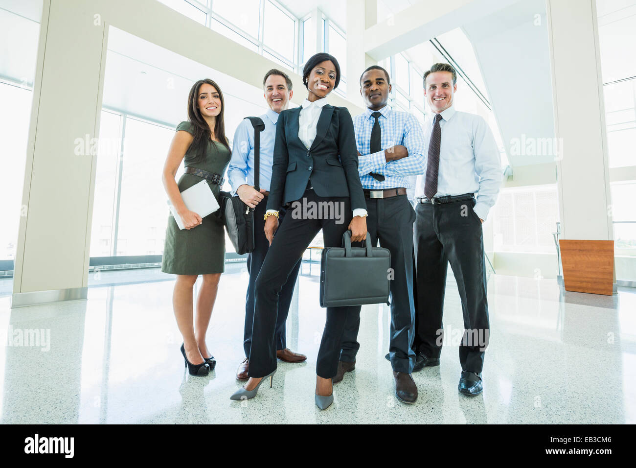 Business people smiling in office lobby Stock Photo - Alamy