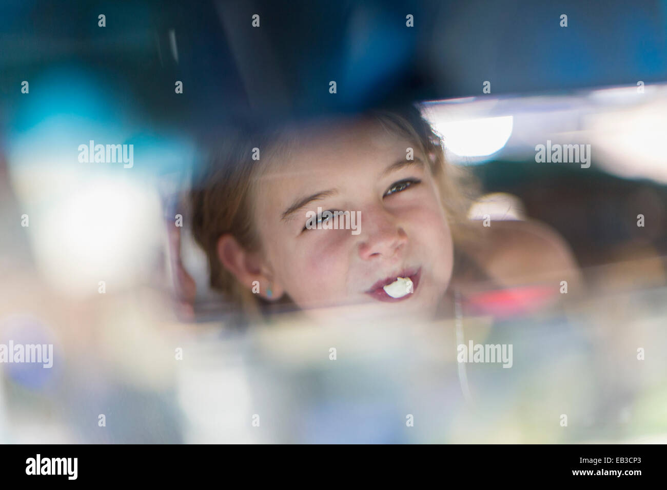Reflection of Caucasian girl blowing bubble gum bubble in rearview mirror Stock Photo Alamy