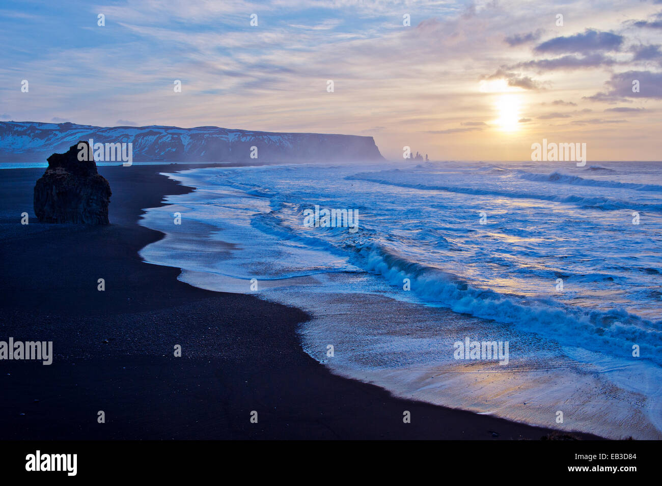 Waves washing up by rock formation on beach Stock Photo