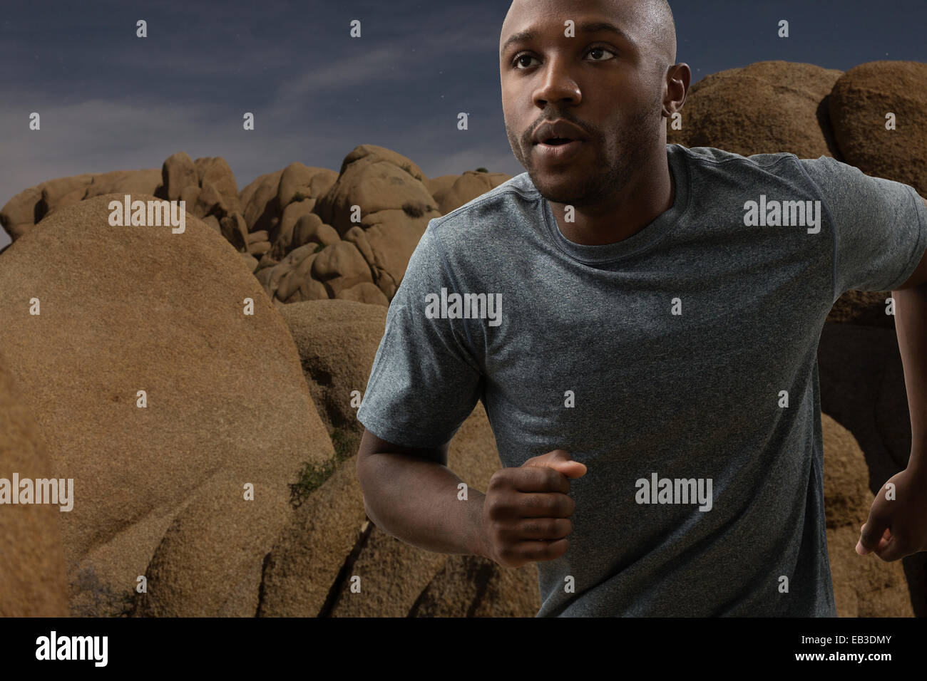 Black man running in rocky remote landscape Stock Photo