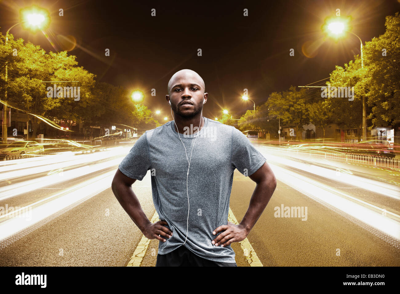Time lapse view of Black runner standing on city street at night Stock Photo