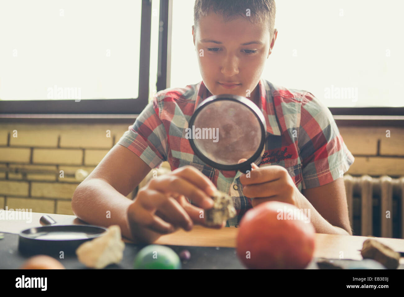 Student examining models of planets in classroom Stock Photo