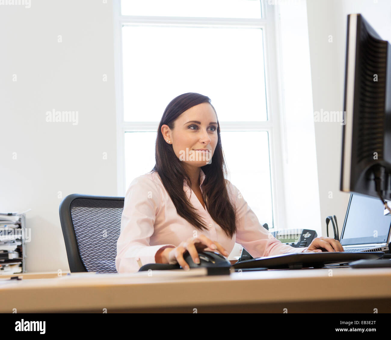 Caucasian businesswoman working on computer at desk Stock Photo - Alamy