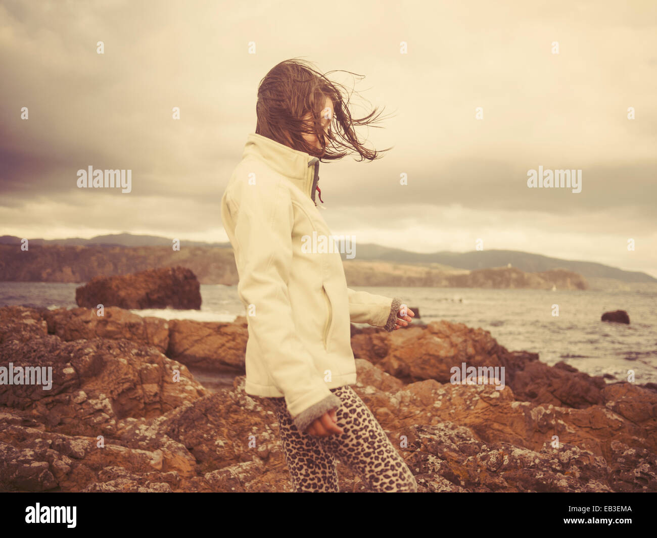 Mixed race girl walking on rocky beach Stock Photo Alamy