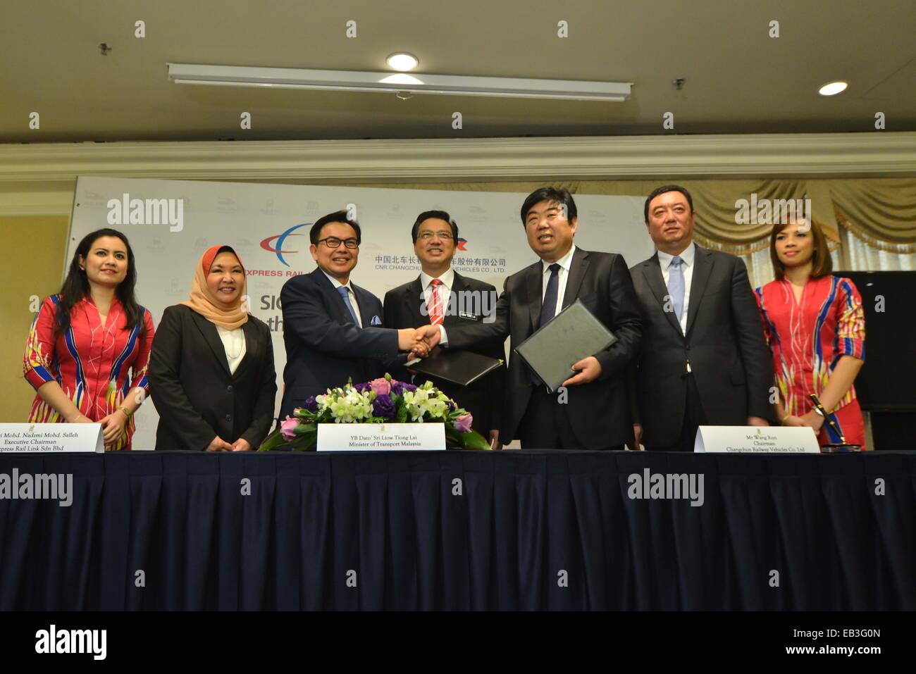 Kuala Lampur, Malaysia. 25th Nov, 2014. Representatives shake hands after signing an agreement in Kuala Lampur, Malaysia, Nov. 25, 2014. China's CNR Changchun Railway Vehicles Co., Ltd. (CRC) signed here Tuesday an agreement with Malaysia's Express Rail Link Sdn. Bhd. (ERL) to supply six sets of four-car trains to the line from Kuala Lumpur city center to Kuala Lumpur International Airport. © Chong Voon Chung/Xinhua/Alamy Live News Stock Photo