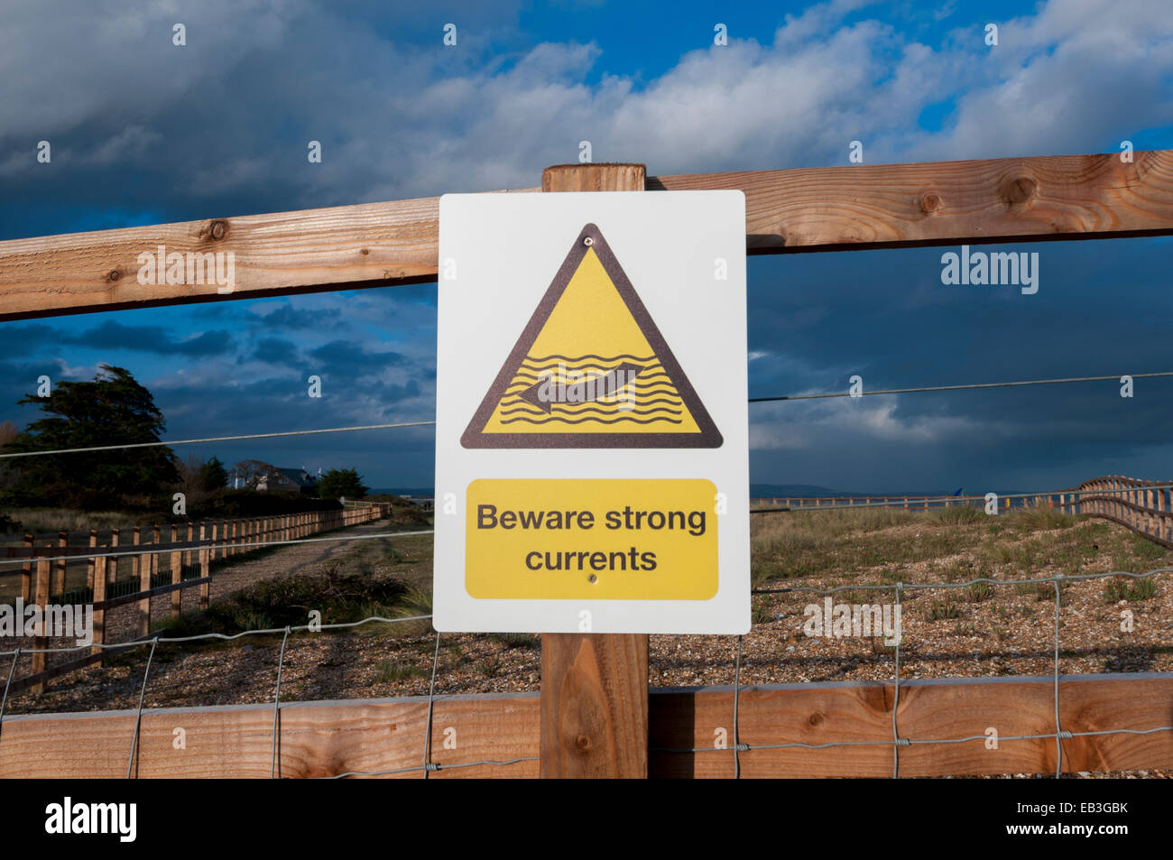 Beware strong currents warning sign by the beach Stock Photo