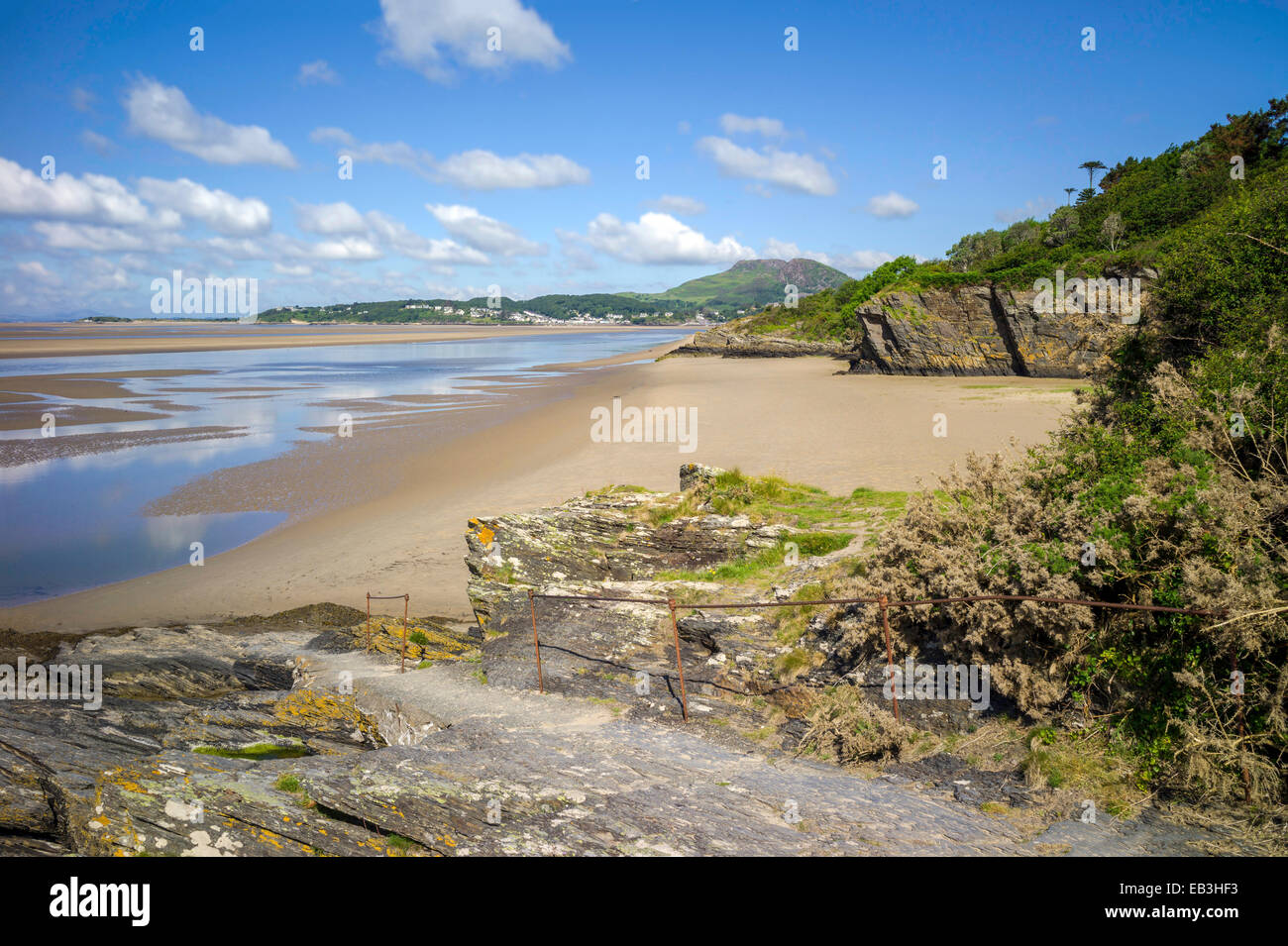 A quiet small sandy bay on the Portmeirion coastal walk on the river Dwyryd estuary. In the background is Borth-y-gest. Stock Photo
