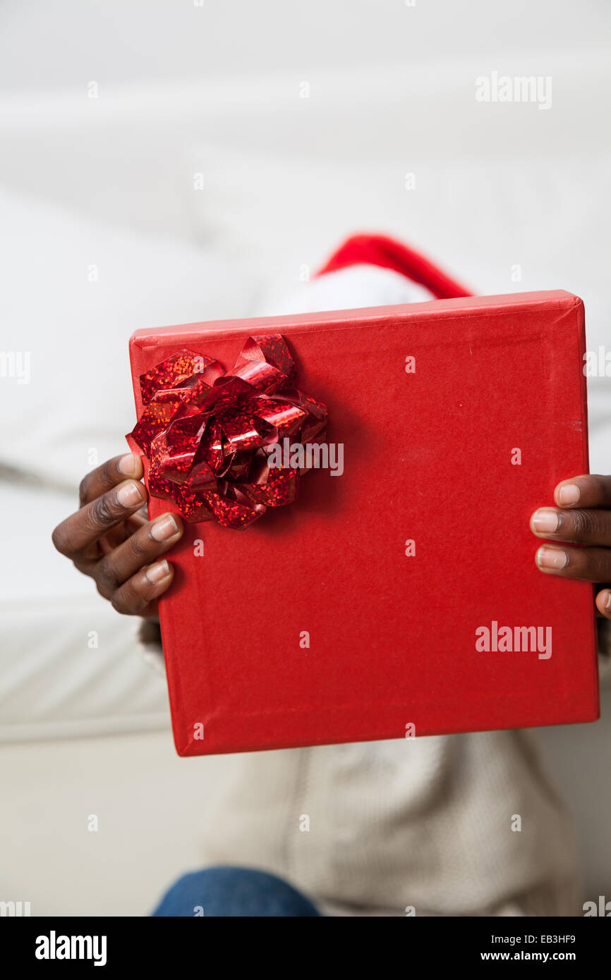 Black man covering his face with gift Stock Photo - Alamy