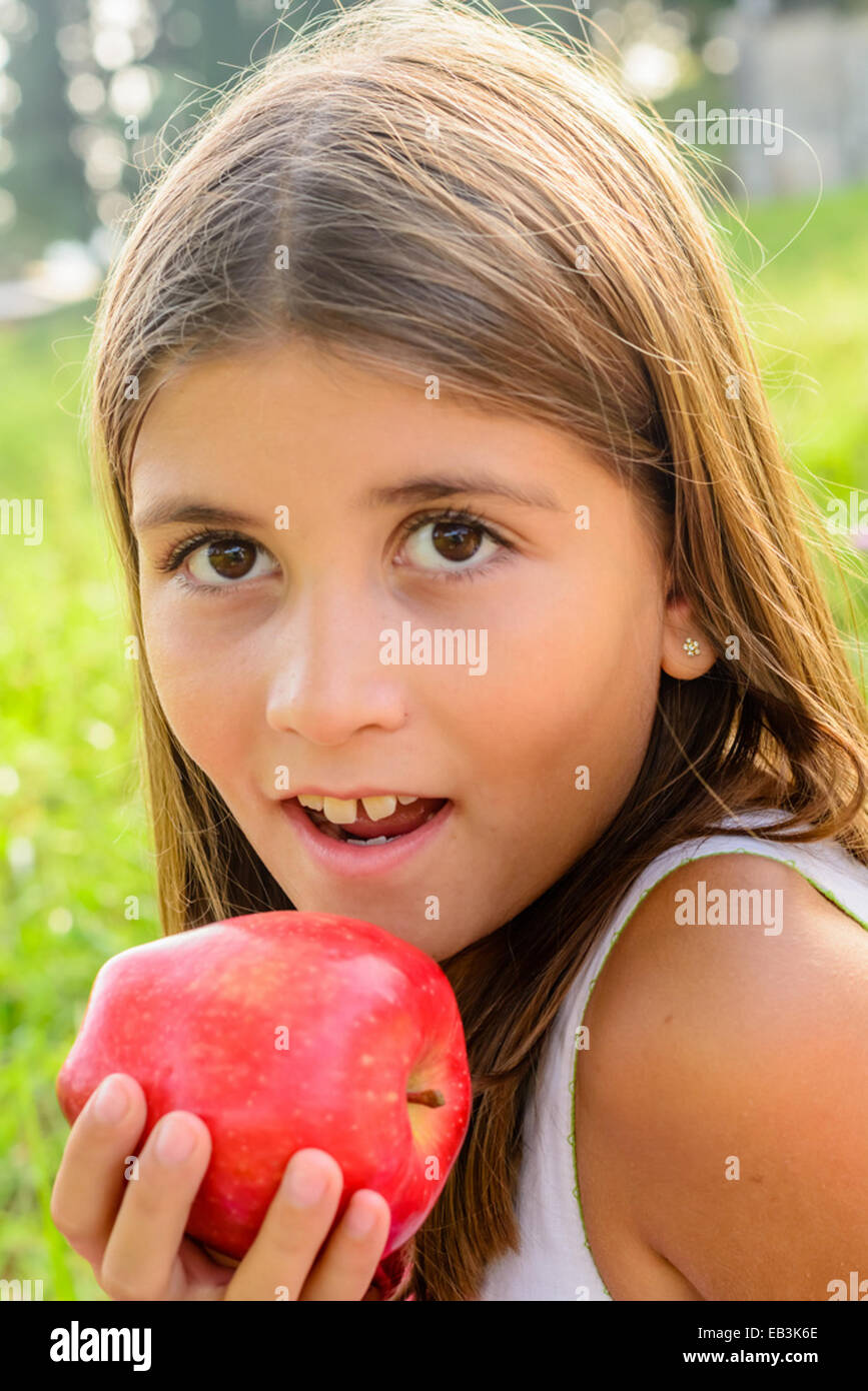 Beautiful nine year old girl  eating apple Stock Photo