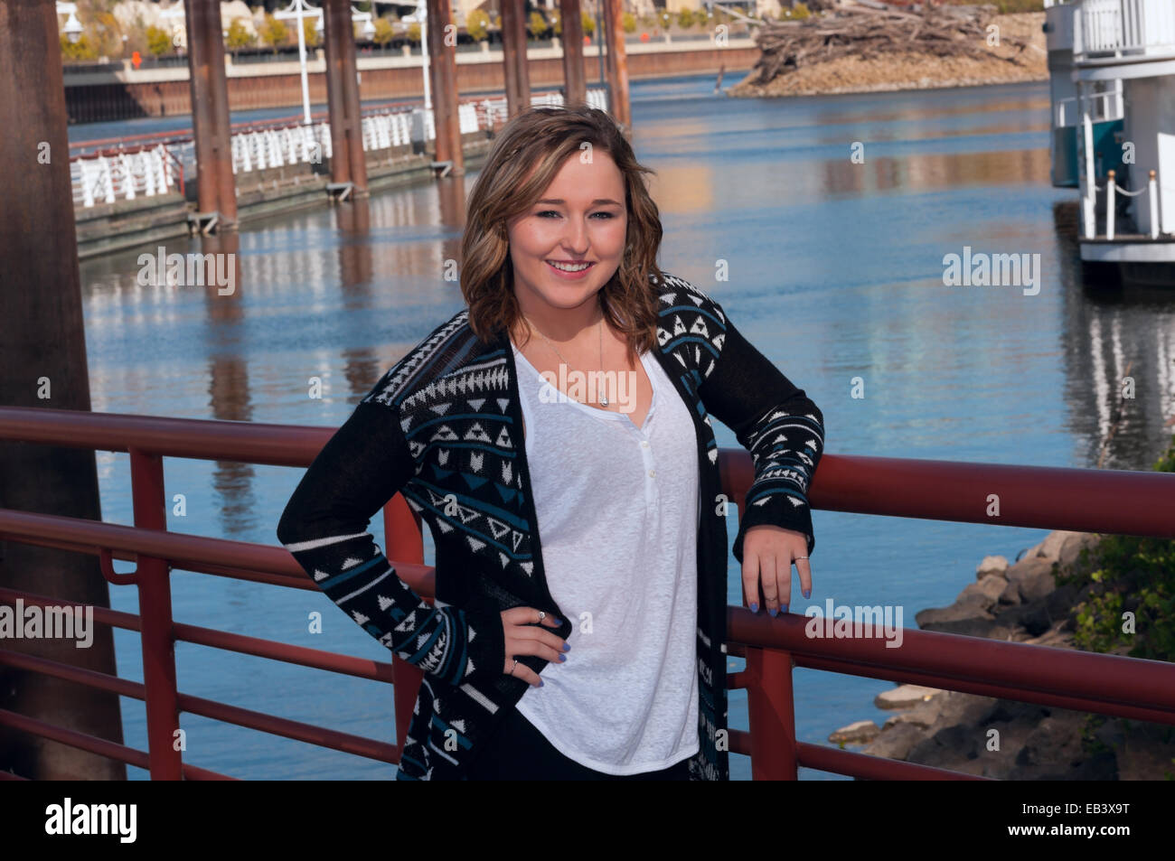 Outdoor portrait of young teen female smiling Mississippi River and downtown saint paul in background Stock Photo