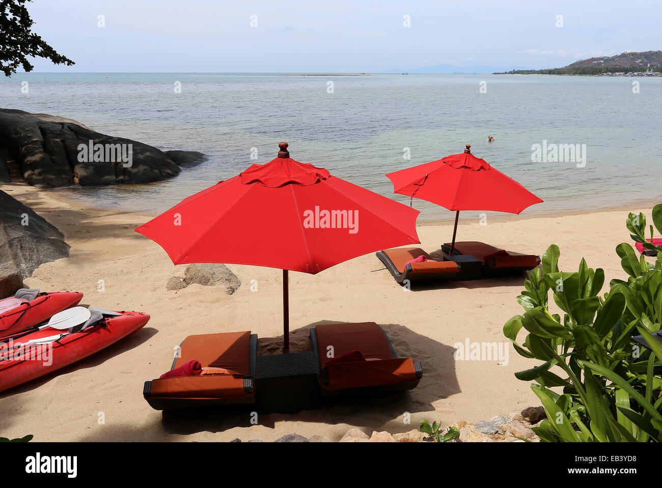 bright red umbrellas on an exotic beach sunny day Stock Photo