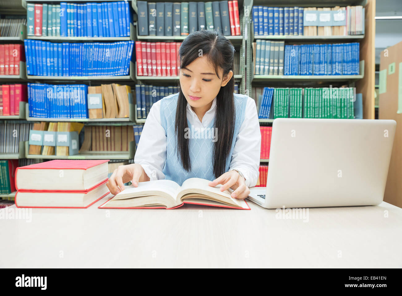 Student with open book reading it in college library Stock Photo