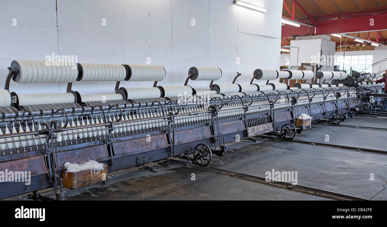 Array of machines for spinning wool in workroom at historic Trefriw Woollen Mills, a popular tourist attraction in Wales Stock Photo