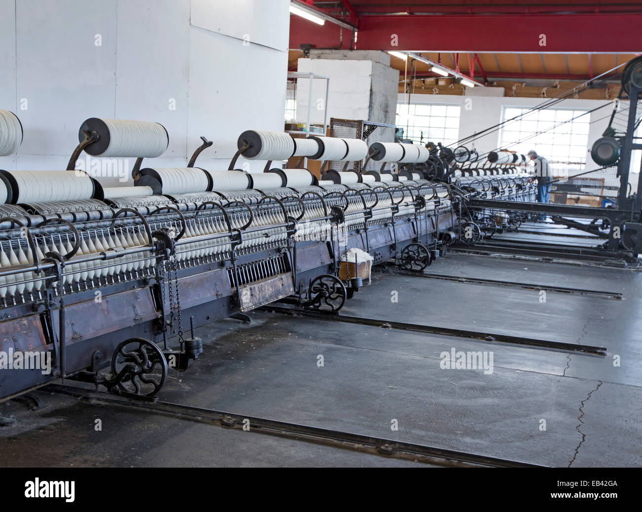 Array of machines for spinning wool in workroom at historic Trefriw Woollen Mills, a popular tourist attraction in Wales Stock Photo