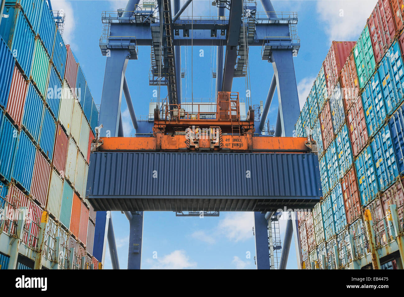 Shore crane lifts container during cargo operation in port Stock Photo