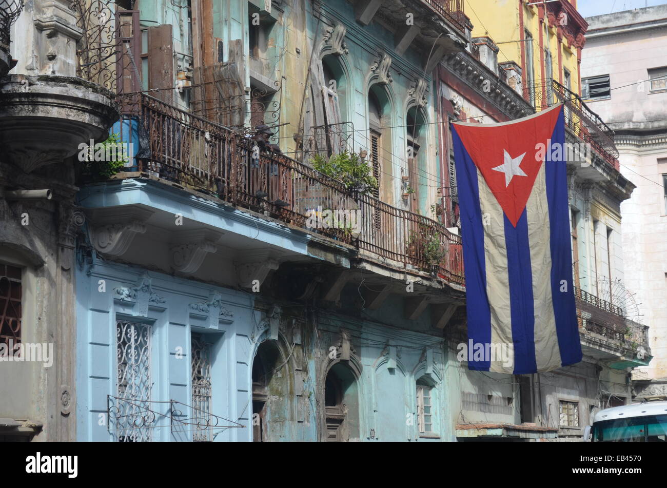 A Cuban Flag hangs over a residential street in Centro Havana Stock Photo
