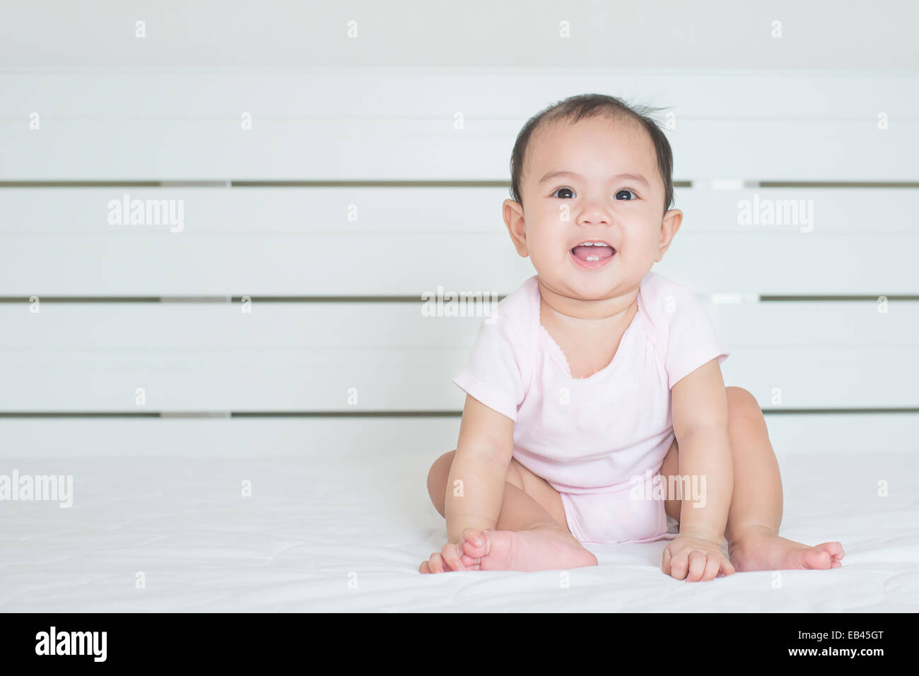 Asian cute girl baby is smiling in bedroom Stock Photo