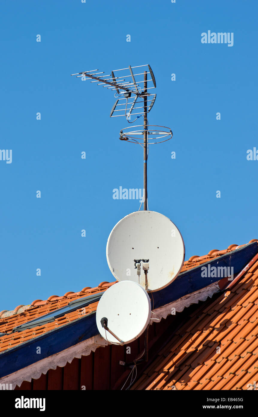 Satellite dishes tv antenna on a tiled roof Stock Photo Alamy