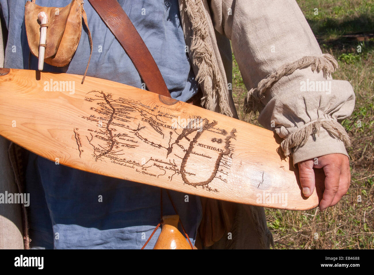 French Voyageur Explorer holding a canoe paddle with an old map of the Great Lakes burned onto it Stock Photo