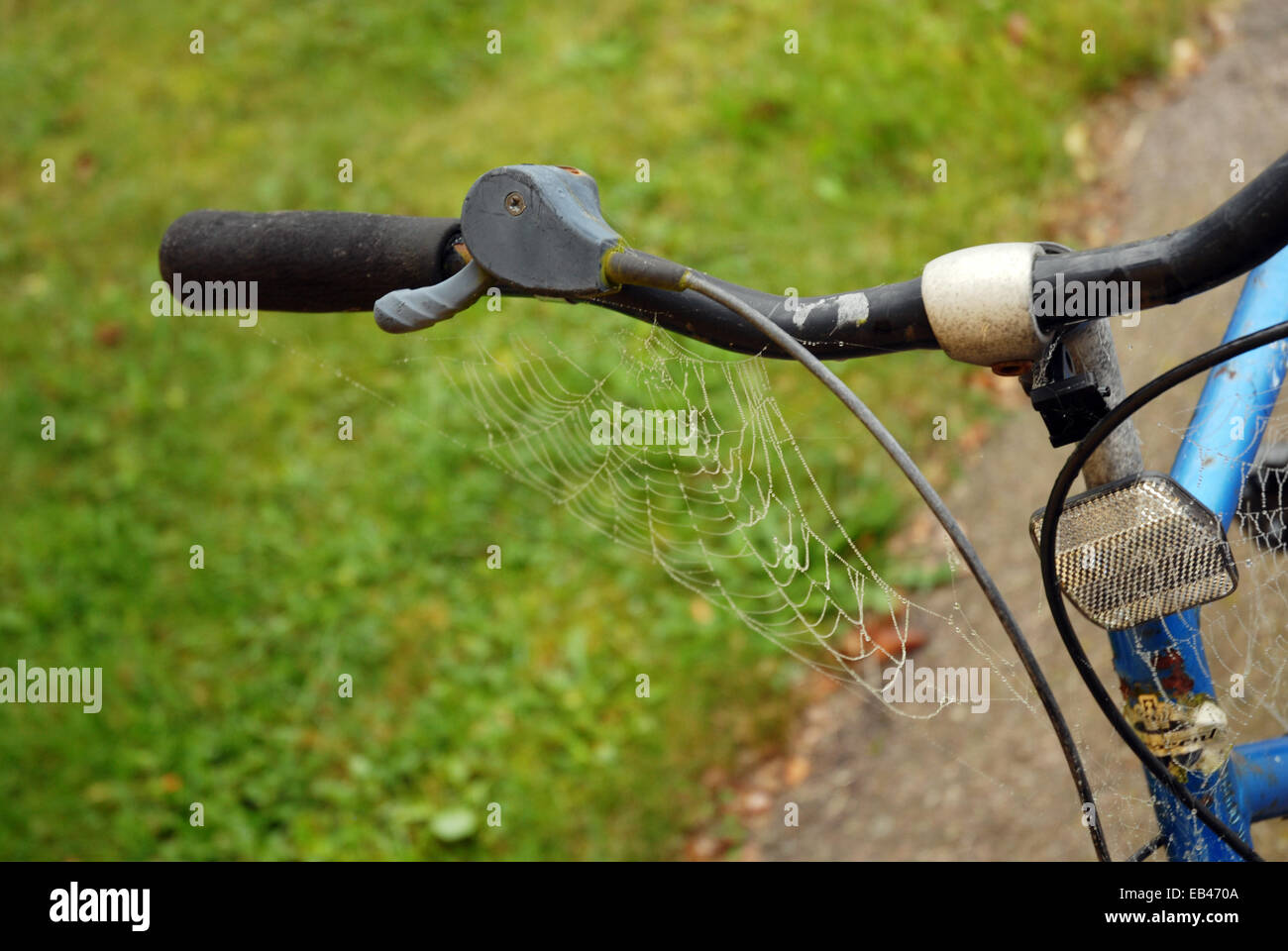 Closeup view of the strings of a cobweb on bicycle handlebar Stock