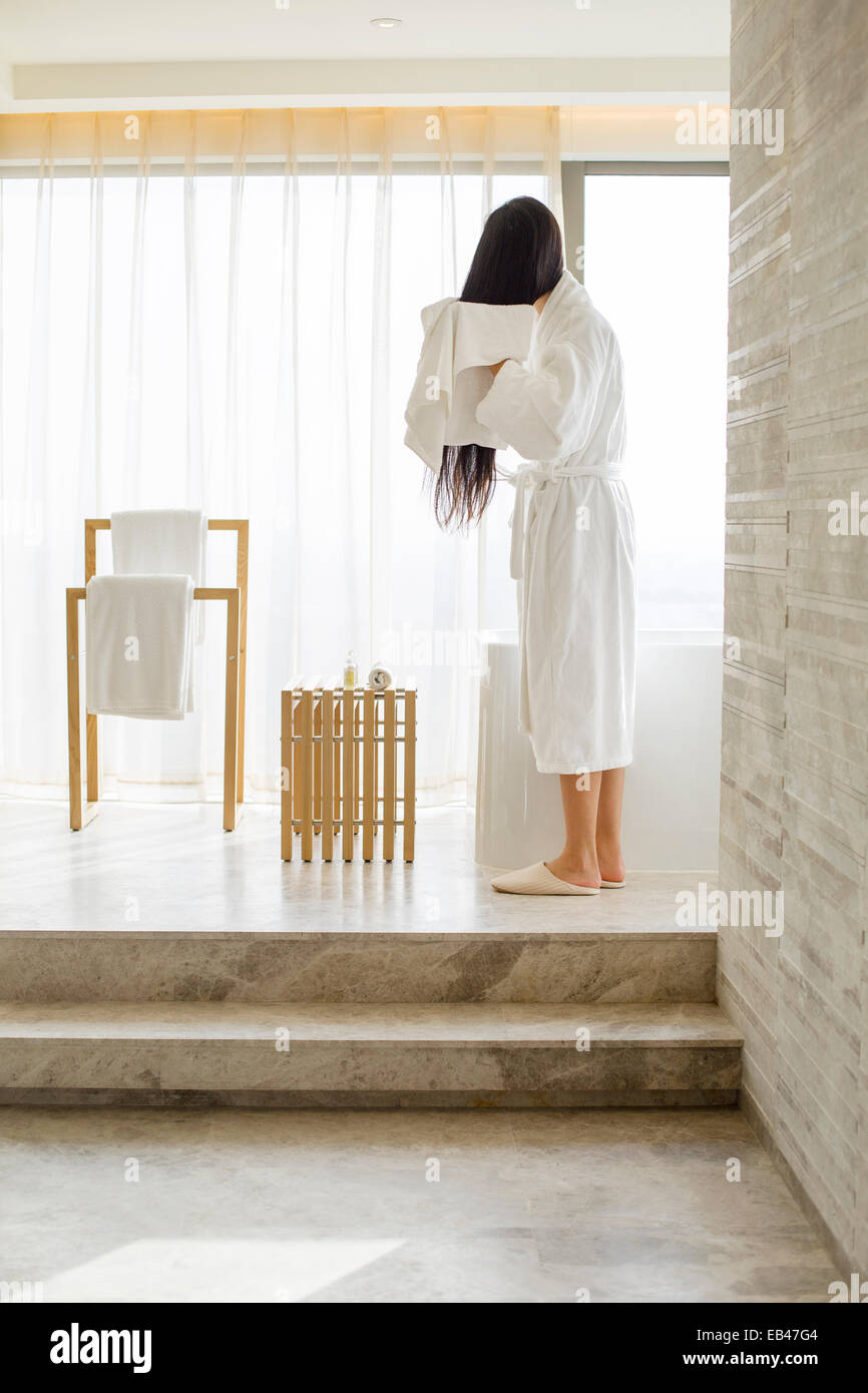 Young woman drying her hair with a towel in bathroom Stock Photo - Alamy