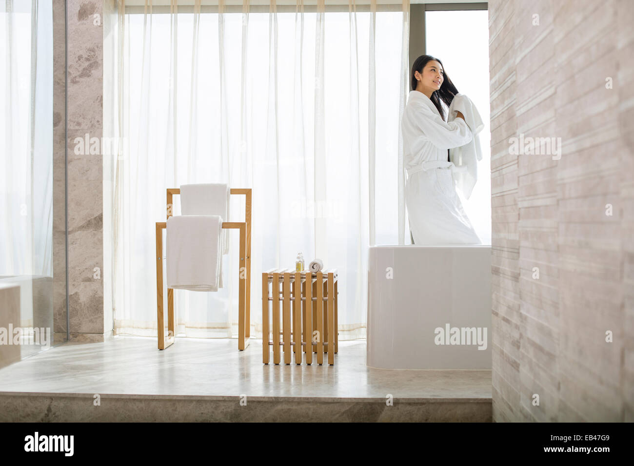 Young woman drying her hair with a towel in bathroom Stock Photo - Alamy
