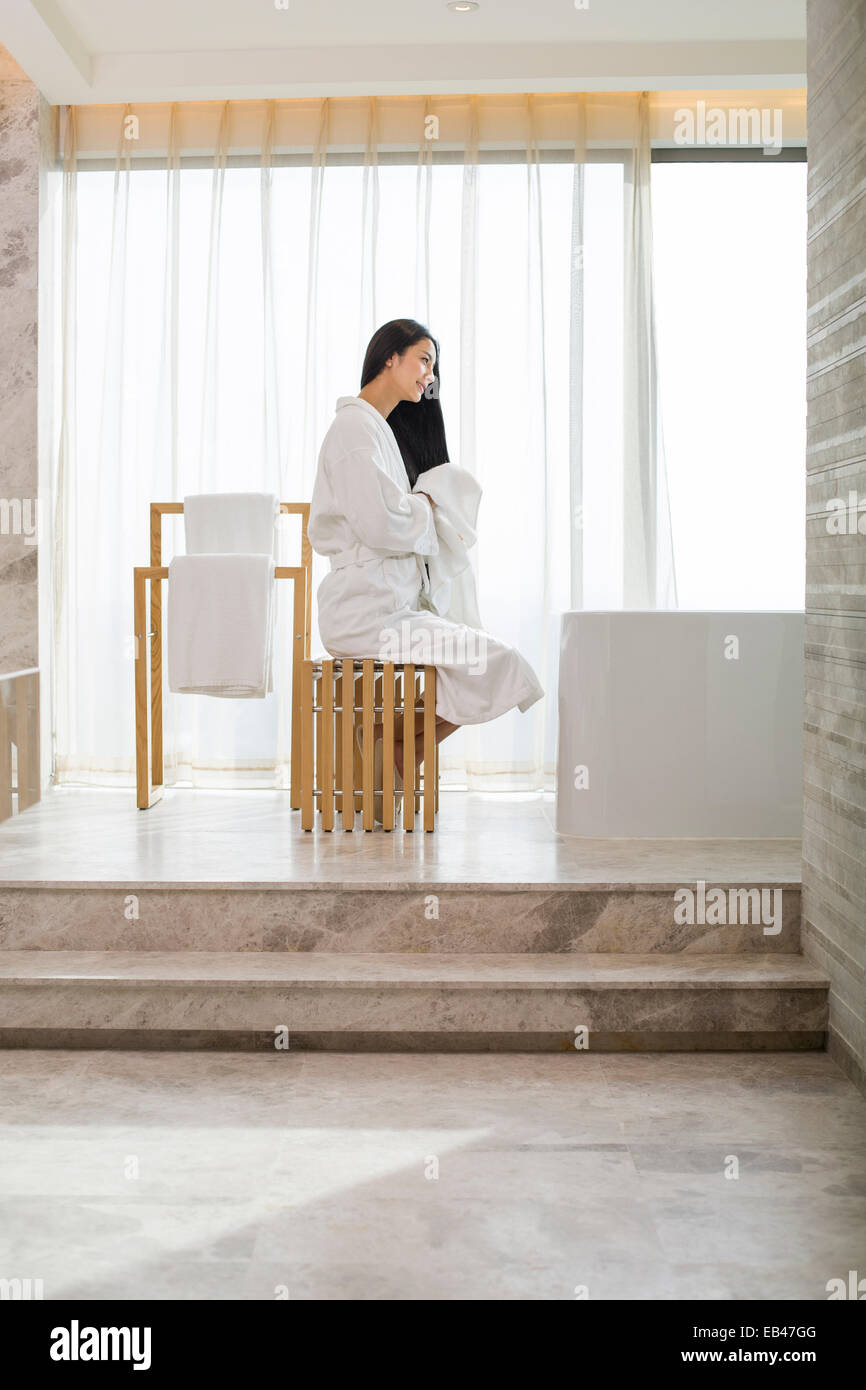 Young woman drying her hair with a towel in bathroom Stock Photo - Alamy
