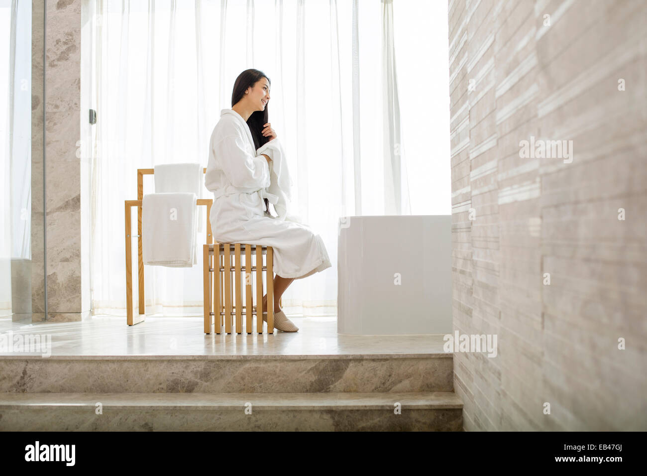 Young woman drying her hair with a towel in bathroom Stock Photo - Alamy