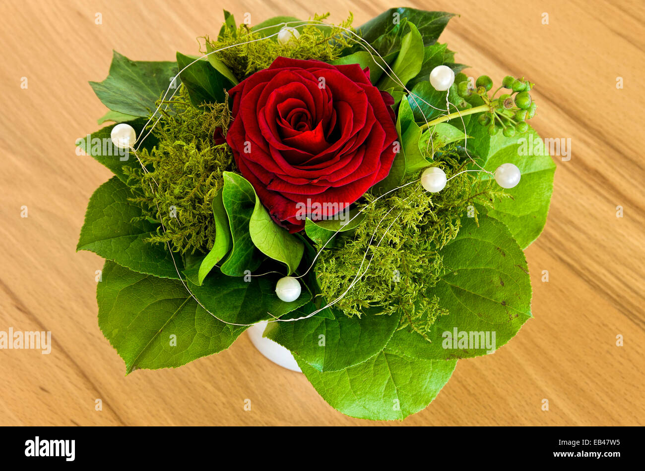 Single rose with greens and deco beads in a bouquet Stock Photo - Alamy