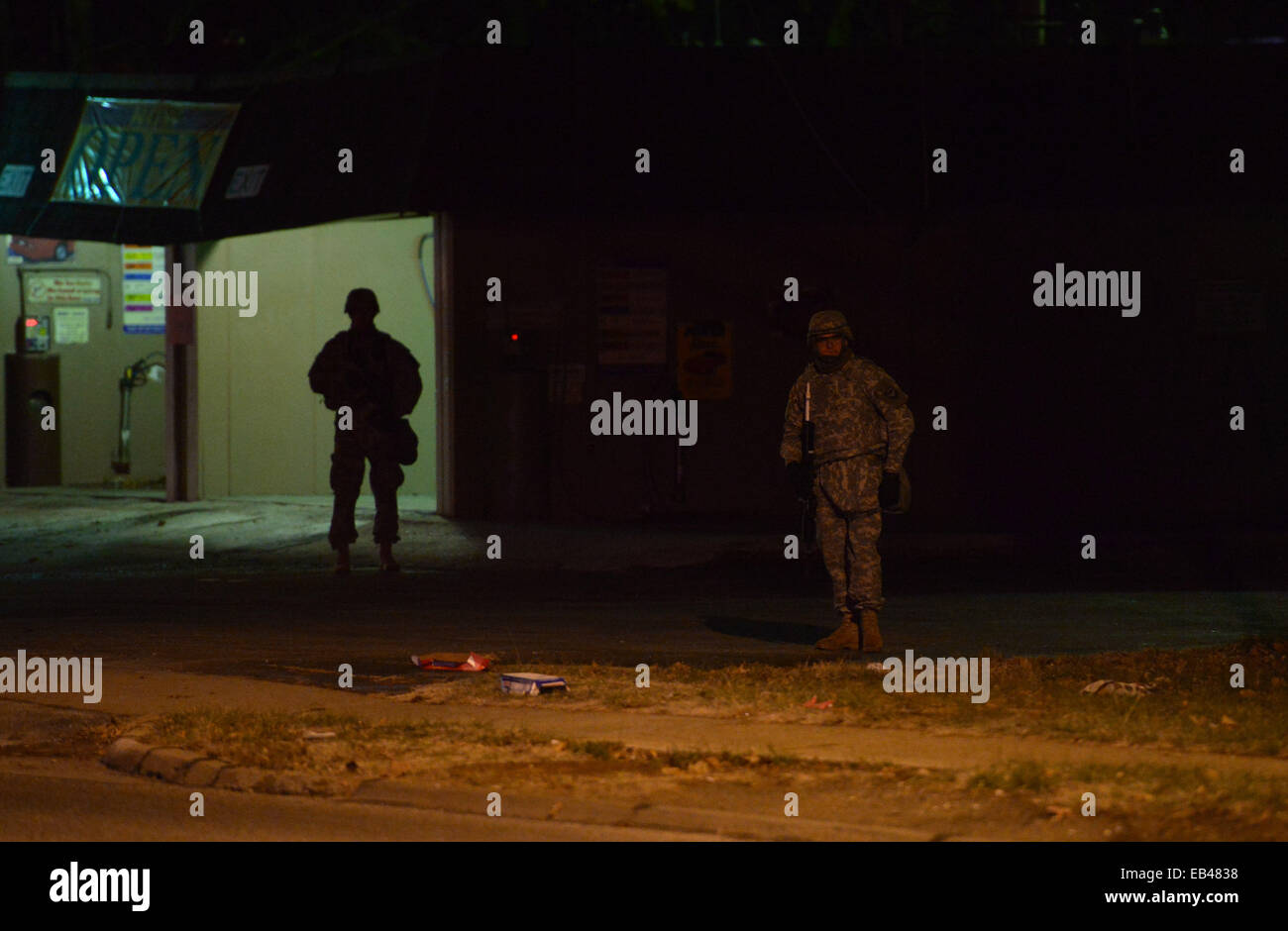 Ferguson, USA. 25th Nov, 2014. Members of National Guard in riot gear stand at the demonstration site outside Ferguson police station, St. Louis County, Missouri, the United States of America, Nov. 25, 2014. More than 1,500 National Guard troops joined about 700 guardsmen who were already on the scene to help local law enforcement protect residents and property in Ferguson, one day after a grand jury declined to hand up an indictment against Ferguson police officer Darren Wilson, who shot and killed unarmed teenager Michael Brown in August. Credit: Yin Bogu/Xinhua/Alamy Live News Stock Photo
