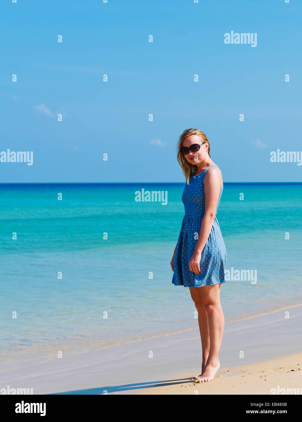 Young woman in dress walking on beach Stock Photo - Alamy