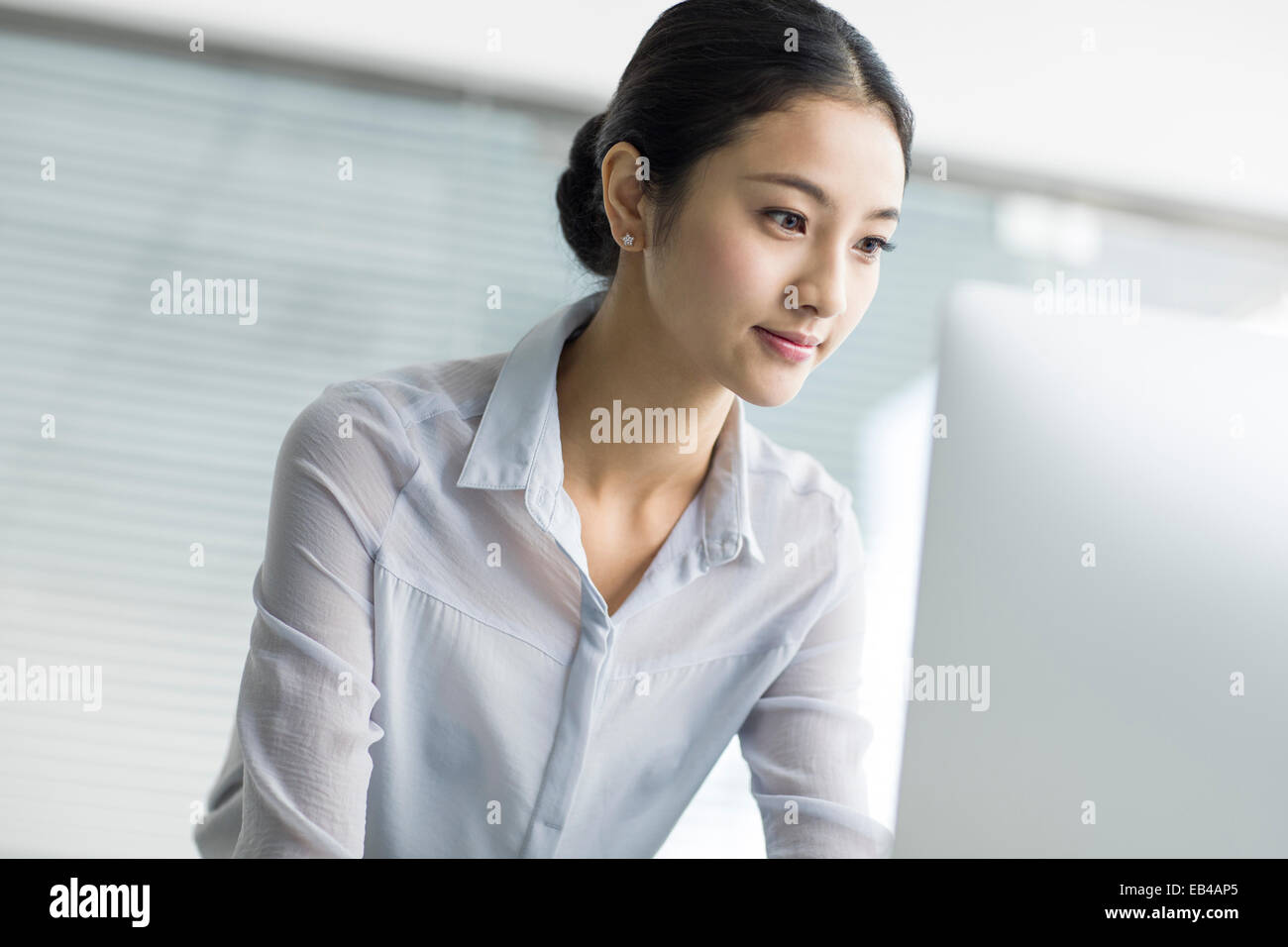 Young businesswoman using computer in office Stock Photo - Alamy